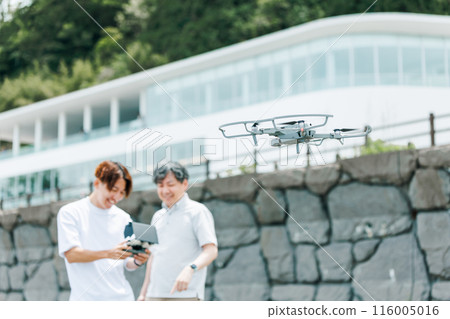 A video creator filming outdoors using a drone A video creator filming outdoors using a drone 116005016