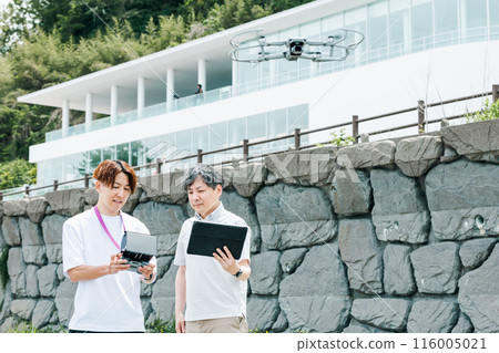 A video creator filming outdoors using a drone 116005021