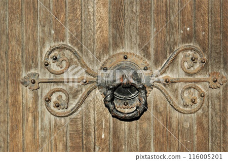 Fragment of an old church door with a metal handle. 116005201