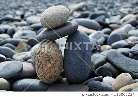The tower is made of various pebbles on a stony beach. 116005224