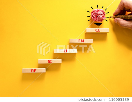 Resilience symbol. Concept word Resilience on beautiful wooden blocks. Light bulb icon. Businessman hand with pen. Beautiful yellow background. Business resilience concept. Copy space. 116005389