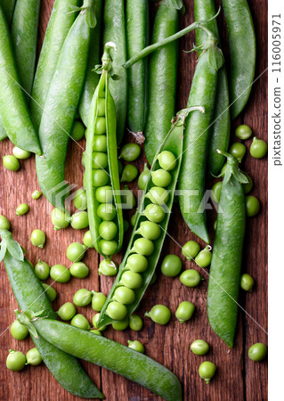 Green sugar snap peas on rustic wooden table close up Green sugar snap peas on rustic wooden table close up 116005971