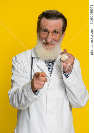 Doctor man showing time on pocket watch clock, ok, thumb up, approve, pointing finger at camera Doctor man showing time on pocket watch clock, ok, thumb up, approve, pointing finger at camera 116006041
