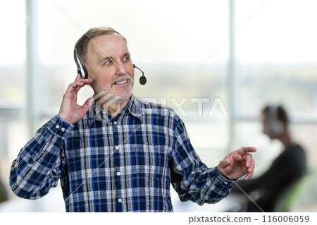 Portrait of happy male call center customer support worker. Office enviroment background. Portrait of happy male call center customer support worker. Office enviroment background. 116006059