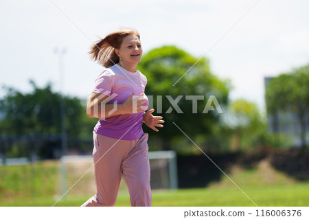 Elderly woman exercising. Fit senior lady running. 116006376