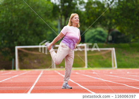 Elderly woman exercising. Fit senior lady running. 116006397