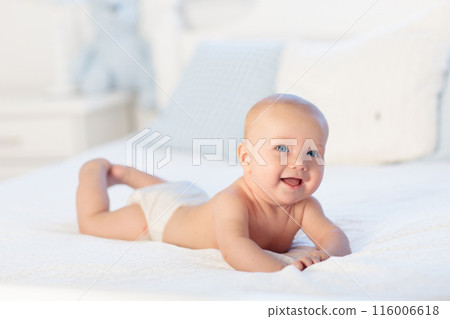Baby boy on white bed Baby boy on white bed 116006618