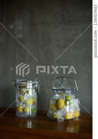 Plums and rock sugar placed in a glass jar to make syrup 116007683