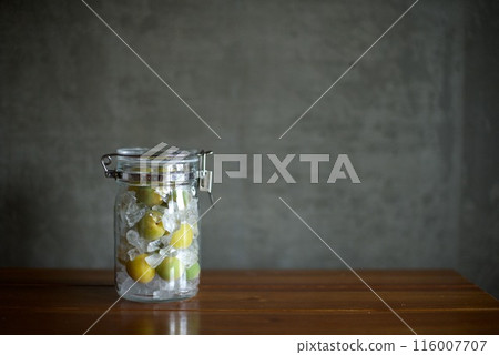 Plums and rock sugar placed in a glass jar to make syrup 116007707