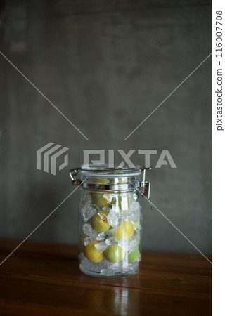 Plums and rock sugar placed in a glass jar to make syrup 116007708