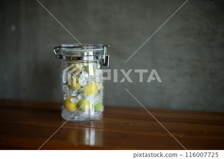 Plums and rock sugar placed in a glass jar to make syrup 116007725