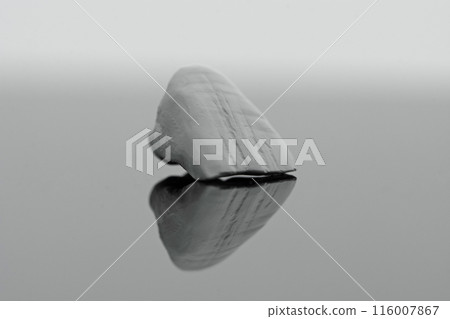 Detalised close-up photo of microstructure on raw zirkonium tooth on light grey background. 116007867