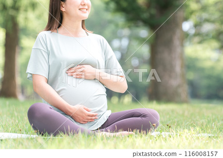 Young Asian woman doing maternity yoga, premama yoga, pilates and stretching in the forest and park Young Asian woman doing maternity yoga, premama yoga, pilates and stretching in the forest and park 116008157