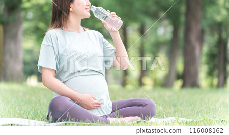 Young Asian woman doing maternity yoga, pre-mom yoga, pilates in forest/park (hydration) Young Asian woman doing maternity yoga, pre-mom yoga, pilates in forest/park (hydration) 116008162