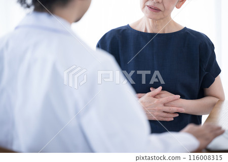 Elderly patient complaining to doctor about physical discomfort, stomach and abdominal pain, no face Elderly patient complaining to doctor about physical discomfort, stomach and abdominal pain, no face 116008315