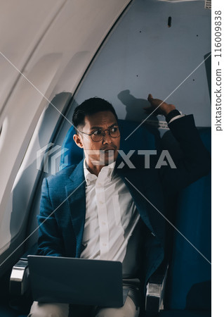 Smart and focused Asian businessman in formal business suit using laptop computer during the flight for his business trip. Business people and transportation concept 116009838