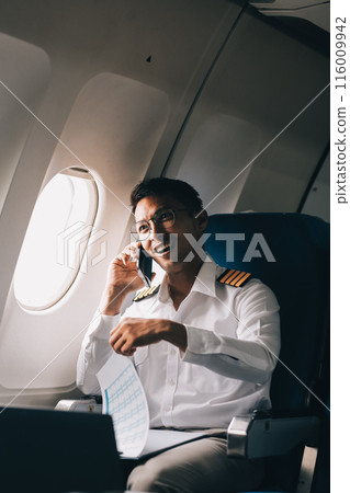 .Portrait of a trained airplane captain in uniform preparing to fly in a simulator cockpit. .Portrait of a trained airplane captain in uniform preparing to fly in a simulator cockpit. 116009942