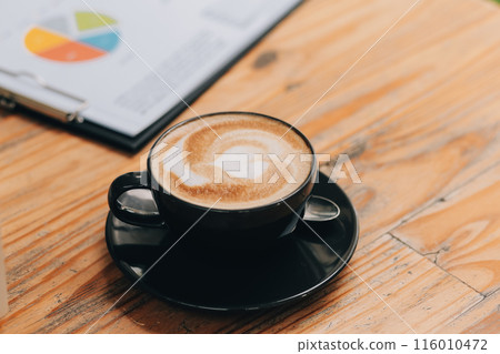 Closeup of coffee cup on table in empty corporate conference room before business meeting in office 116010472