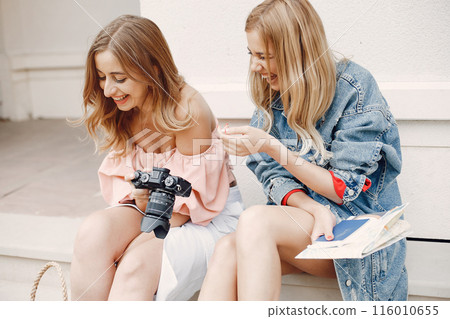 Beautiful girl in a blue jacket. Women sitting with a camera. Girl make a photo for her girlfriend Beautiful girl in a blue jacket. Women sitting with a camera. Girl make a photo for her girlfriend 116010655