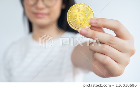 Woman holding a Bitcoin token. 116010690