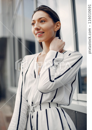 Beautiful girl in a city. Stylish girl near gray building 116010691