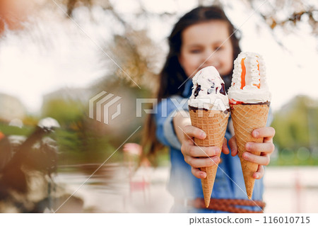 Beautiful little girl in a blue blouse. Child in a summer park 116010715