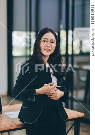 Happy young asian woman, using digital tablet isolated on office background Happy young asian woman, using digital tablet isolated on office background 116010911