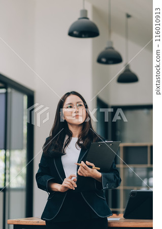 Happy young asian woman, using digital tablet isolated on office background Happy young asian woman, using digital tablet isolated on office background 116010913