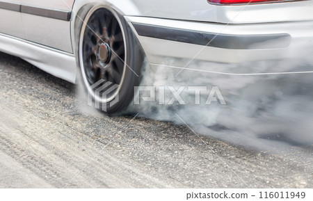 EV drag racing car is burning tire at start line. 116011949