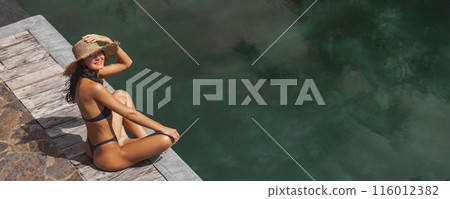 Woman Smiling by Pool with Sun Hat 116012382