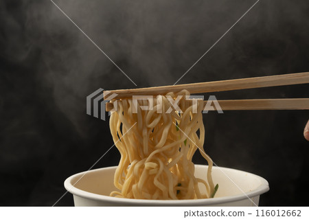 Cup noodles, instant ramen, pick up noodles with chopsticks 116012662