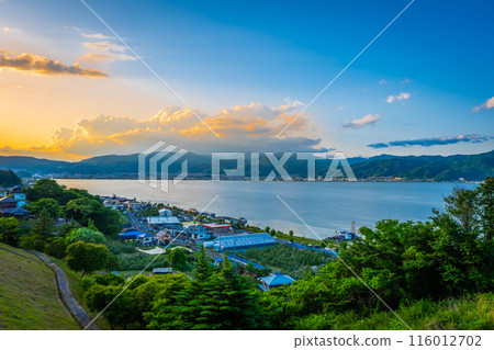 View of Suwa lake in Nagano, Japan in sunset time with city and mountain background. Landscape photo View of Suwa lake in Nagano, Japan in sunset time with city and mountain background. Landscape photo 116012702