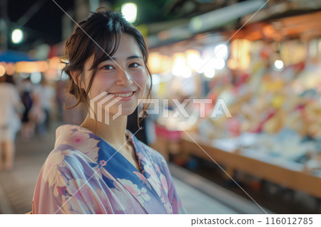 A woman in a yukata enjoying a night market 116012785