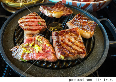 Large pieces of marbled wagyu beef grilled on a pan are a high quality and famous premium beef from Hida, Japan. 116013039