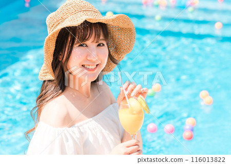 Young Asian woman drinking tropical juice by the pool (resort vacation) Young Asian woman drinking tropical juice by the pool (resort vacation) 116013822