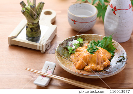 Sea urchin and sake served on a Japanese plate 116013977