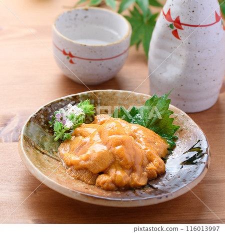 Sea urchin and sake served on a Japanese plate Sea urchin and sake served on a Japanese plate 116013997