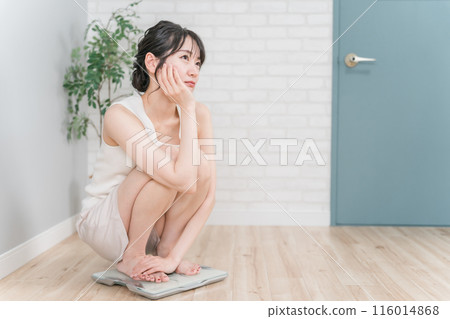 Slim Asian woman on a weight scale (diet/slimming image) 116014868