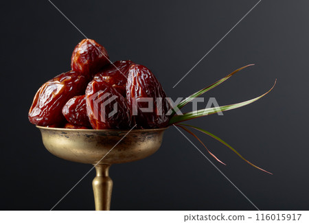Closeup sweet dried dates in brass dish. Closeup sweet dried dates in brass dish. 116015917