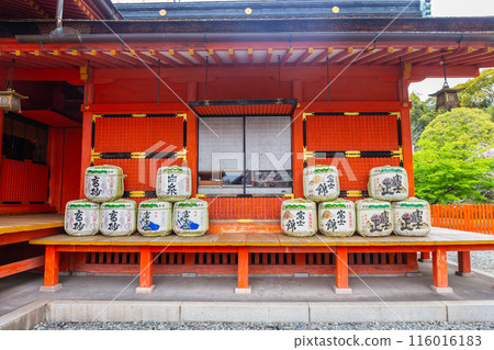 Fujinomiya, Japan April 8, 2024: Sake fermentation tank in Fujisan Hongu Sengen Taisha Shinto Shrine where cherry blossoms are blooming on a rainy day at Shizuoka, Japan. Fujinomiya, Japan April 8, 2024: Sake fermentation tank in Fujisan Hongu Sengen Taisha Shinto Shrine where cherry blossoms are blooming on a rainy day at Shizuoka, Japan. 116016183