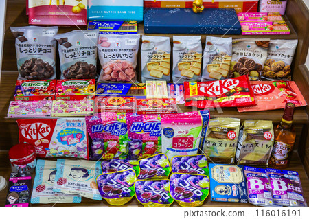 TOKYO, JAPAN - April 11, 2024 :  Mix collection of snacks, food, souvenirs, supplements, beverages clothing and liquor that are popular in Japan for foreign tourists use for background. 116016191