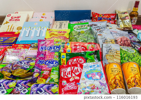 TOKYO, JAPAN - April 11, 2024 :  Mix collection of snacks, food, souvenirs, supplements, beverages clothing and liquor that are popular in Japan for foreign tourists use for background. 116016193