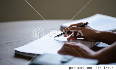 Female entrepreneur working to reading document and writing notes while analysis finance of startup Female entrepreneur working to reading document and writing notes while analysis finance of startup 116016597