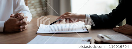 Real estate agent woman explains house insurance and pointing with pen for client signing contract Real estate agent woman explains house insurance and pointing with pen for client signing contract 116016704