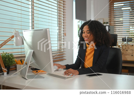 Modern stylish young African businesswoman working at her workplace Modern stylish young African businesswoman working at her workplace 116016988
