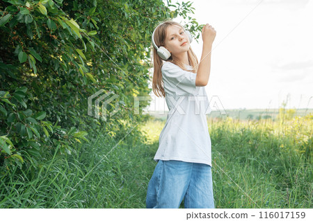 A child with headphones listening to music and dancing A child with headphones listening to music and dancing 116017159