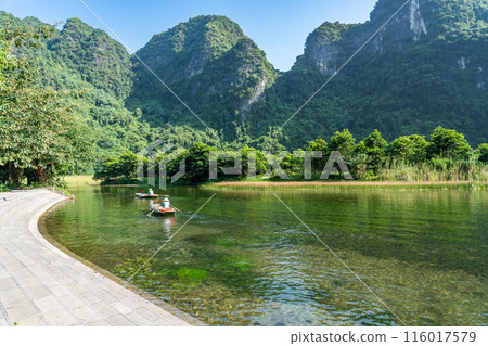 Vietnam Hanoi: Rowers on a Ninh Binh boat tour rowing a river in a valley Vietnam Hanoi: Rowers on a Ninh Binh boat tour rowing a river in a valley 116017579