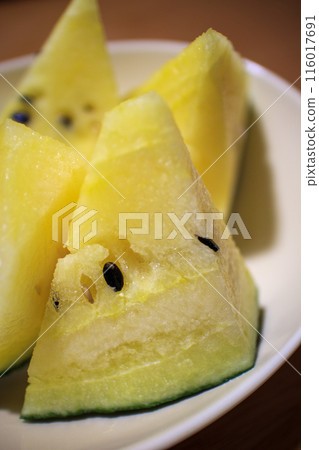 Sliced yellow watermelon served on a plate (vertical composition) Sliced yellow watermelon served on a plate (vertical composition) 116017691