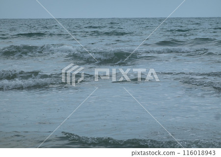 Ocean waves crash onto a sandy beach Ocean waves crash onto a sandy beach 116018943