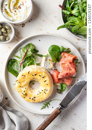 Homemade bagel sandwich with smoked salmon, cream cheese, capers and spinach for healthy breakfast top view 116019187